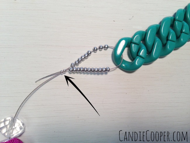 Thread the tail of wire through 2 crimp beads